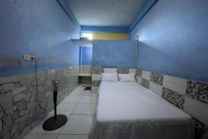 una camera con un letto in una camera blu di SPOT ON 93879 Wunut Homestay Syariah a Sidoarjo