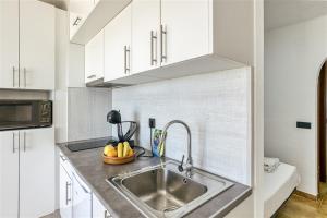 a kitchen with a stainless steel sink and white cabinets at Cosy Beach II in Empuriabrava