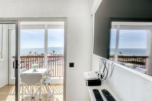 a room with a desk with a phone and a balcony at Cosy Beach II in Empuriabrava