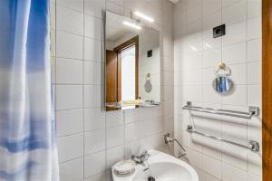 a white bathroom with a sink and a mirror at Cosy Beach II in Empuriabrava
