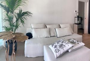 un sofá blanco con almohadas en la sala de estar en Apartma Enjoy, en Ankaran