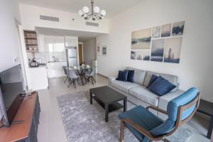 salon z kanapą i stołem w obiekcie Golden Glitter 1 Bedroom in Downtown Dubai w Dubaju