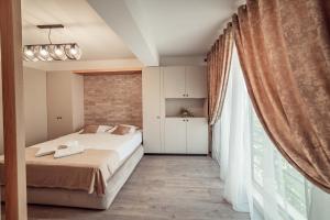 um quarto com uma cama e uma grande janela em Palace of Culture & Palas Mall Collection Suites & Studios em Iaşi