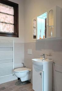 ein weißes Bad mit einem WC und einem Waschbecken in der Unterkunft Casa Dell'Arte Botanica in Palaia