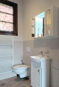 a white bathroom with a toilet and a sink at Casa Dell'Arte Botanica in Palaia +8 photos