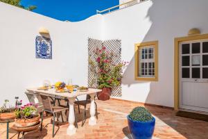 a patio with a table and chairs and flowers at Villa Glamour by Portucasa in Armação de Pêra