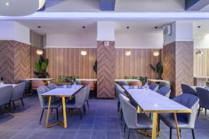 a restaurant with tables and chairs in a room at S&E Hotel in Tainan