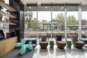 a lobby with chairs and a pool in the background at S&E Hotel in Tainan