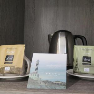 czajnik do herbaty i dwie paczki kawy na talerzach w obiekcie Hotel Eden Park by Brava Hoteles w mieście Riudellots de la Selva