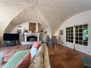 sala de estar con sofá y chimenea en Mas de la Coquille, en Castries