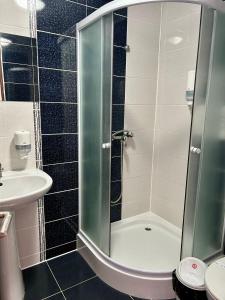 a bathroom with a shower and a sink at Aranykakas étterem és panzió in Sîndominic