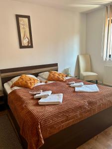 1 dormitorio con 1 cama con toallas en Aranykakas étterem és panzió, en Sîndominic