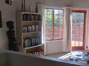 une chambre avec une étagère remplie de livres dans l'établissement Anchorage Inn, à Montagu