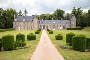 a large brick building with a pathway in the grass at Studio lumineux Entrée privée Bocage Normand in Moncy