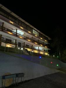 um grande edifício com luzes acesas à noite em ASHRAMAM HEALTH RESORT em Kattappana