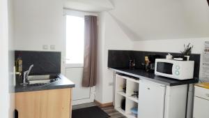 a small kitchen with a sink and a microwave at Studio lumineux Entrée privée Bocage Normand in Moncy