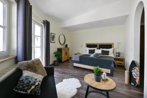 ein Wohnzimmer mit einem Bett und einer Couch in der Unterkunft ALPHAtauern Health Resort - Adults Only 15 plus in Obertauern