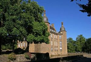 a large brick building with a tree in front of it at Studio lumineux Entrée privée Bocage Normand in Moncy