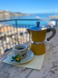 eine Kaffeekanne und eine Tasse Kaffee auf dem Tisch in der Unterkunft La casetta al mare in Palermo