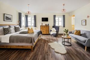 ein Schlafzimmer mit einem Bett, einer Couch und einem Fernseher in der Unterkunft ALPHAtauern Health Resort - Adults Only 15 plus in Obertauern