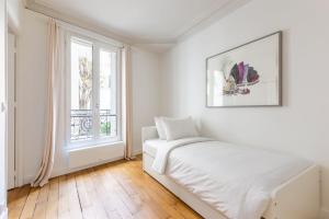 um quarto branco com uma cama e uma janela em Tour Eiffel - Invalides - Rénové em Paris
