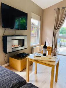 a living room with a table with a bottle of wine at Mariners Lodge in Saint Minver