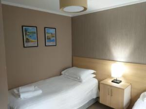 una habitación de hotel con 2 camas y una lámpara en Mariners Lodge en Saint Minver