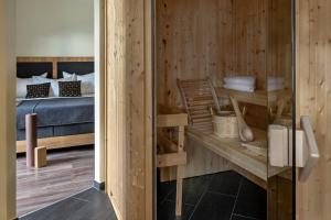 ein Schlafzimmer mit einem Bett und Holzwänden in der Unterkunft ALPHAtauern Health Resort - Adults Only 15 plus in Obertauern