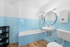 Baño azul con lavabo y espejo en Modernes Apartment mit Balkon, en Brunswick