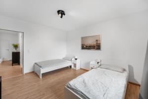 Habitación blanca con 2 camas y espejo. en Modernes Apartment mit Balkon, en Brunswick