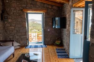 a room with a door leading to a patio at Pappou's Traditional Cottage at Epano Elounda in Elounda
