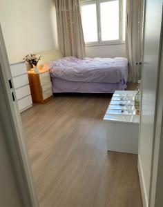 sypialnia z łóżkiem i drewnianą podłogą w obiekcie Une chambre très proche de Paris w mieście Vitry-sur-Seine