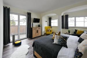 ein Schlafzimmer mit Bett und ein Wohnzimmer in der Unterkunft ALPHAtauern Health Resort - Adults Only 15 plus in Obertauern
