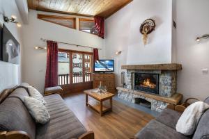 uma sala de estar com um sofá e uma lareira em Les Suites du Val Claret em Tignes