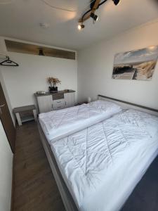 ダンプにあるFerienwohnung Meeresglückの部屋にある大きな白いベッドのある寝室