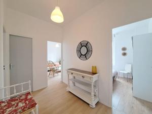een witte kamer met een tafel en een spiegel bij Nairobi, Appartement Cosy in Reims
