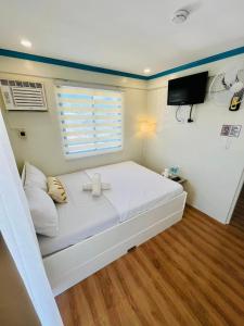 a bedroom with a large white bed with a window at Caleo Boracay Island Station 3 in Boracay