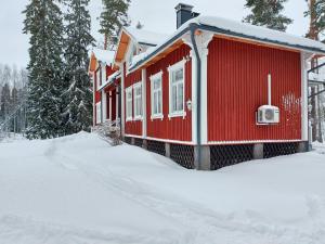 a red house with snow on the ground at Inhan Kartano in Ähtäri