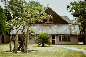 uma casa com árvores em frente em Unyati Safari Lodge em Hectorspruit