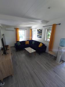 a living room with a couch and a table at T4 à 3mn à pied du lagon in Saint-Leu