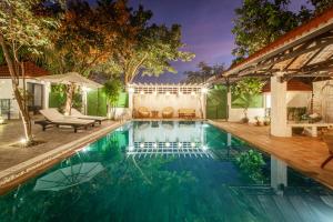 a swimming pool in a backyard with a house at Angkor Eden Boutique Hotel in Siem Reap