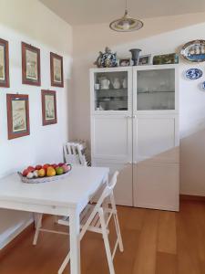 - une cuisine blanche avec une table et des chaises blanches dans l'établissement Il Giardino di Minù, à Monterosi