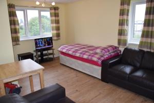 a living room with a bed and a couch at One Bedroom Flat, Granary Road in Ponders End