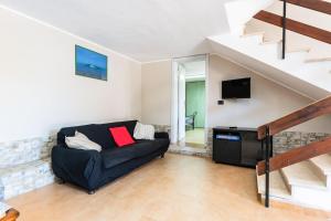 a living room with a couch and a tv at Casa Vacanza Olmi in Capitana