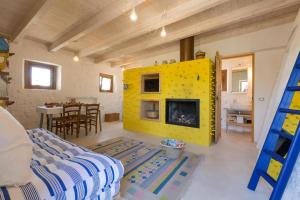 een woonkamer met een gele open haard in een huis bij Trullo Salento in Corigliano dʼOtranto