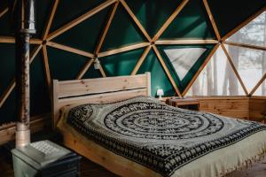 Ce lit se trouve dans un dortoir doté d'un mur vert. dans l'établissement Asalnai Campsite, à Ignalina