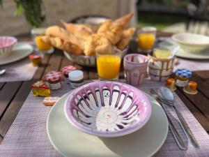 einen Tisch mit einem Teller mit Lebensmitteln und Gläsern Orangensaft in der Unterkunft Résidence Les Sources in Saint-Rémy-de-Provence