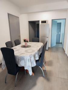 ein Esszimmer mit einem Tisch und Stühlen sowie einem Kühlschrank in der Unterkunft Apartman Marija in Perušić