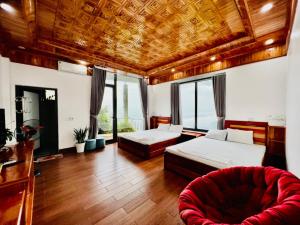 a bedroom with two beds and a red couch at Ruby Tam Đảo in Tam Ðảo +116 photos