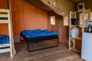 um quarto com uma cama numa tenda em Safaritent op groen en kindvriendelijk park op de Veluwe em Epe